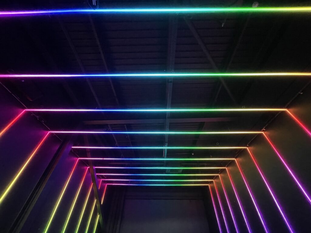 Black aluminium profile with lighting attached in a rainbow pattern